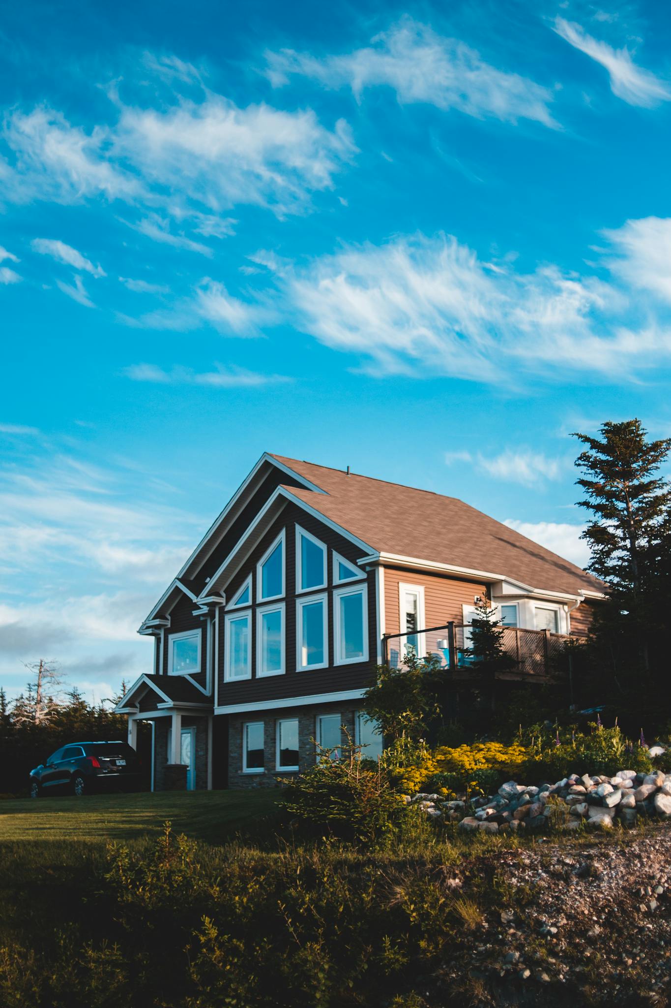 Charming modern house in rural setting with vibrant sky and lush greenery.